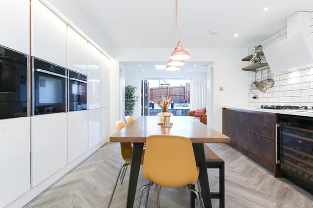 The high spec gloss white kitchen, features Corian worktops, a boiling water tap and a full complement of integrated Neff appliances, including a coffee machine, combi steam oven and a wine fridge. 
