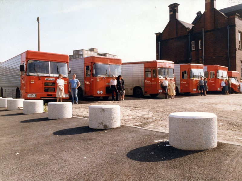 Leeds City Libraries' contingent of Mobile Libraries, parked in the yard outside the old library headquarters on York Road. The headquarters were based in the former York Road Branch Library and Public Baths building, seen on the right. Each mobile was staffed at the time by a driver and an assistant, seen pictured here outside their vans. The area in the foreground is now taken up by Great Clothes.