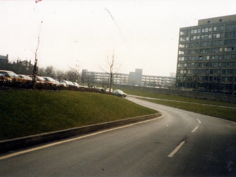 Looking across the Inner Ring Road to buildings of Leeds Polytechnic (now Leeds Metropolitan University) on the right, taken from Vernon Road. A multi-storey car park on New Woodhouse Lane is seen in the centre background, while an outdoor car park is on the left.