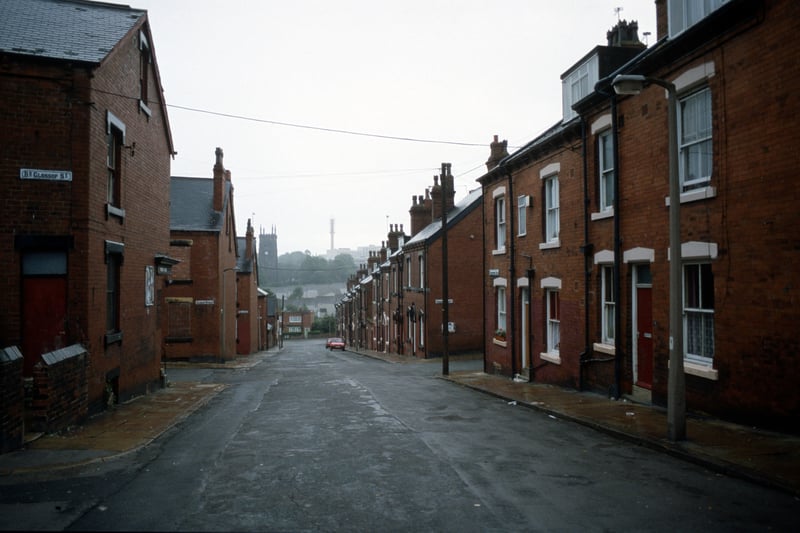 Looking south along Christopher Road towards Woodhouse Street in an area of red brick terraced housing. Streets leading off include Back Glossop Street, Glossop Street and Beulah View on the left and Cross Quarry Street on the right. St. Mark's Church is visible in the distance. Pictured in August 1985.