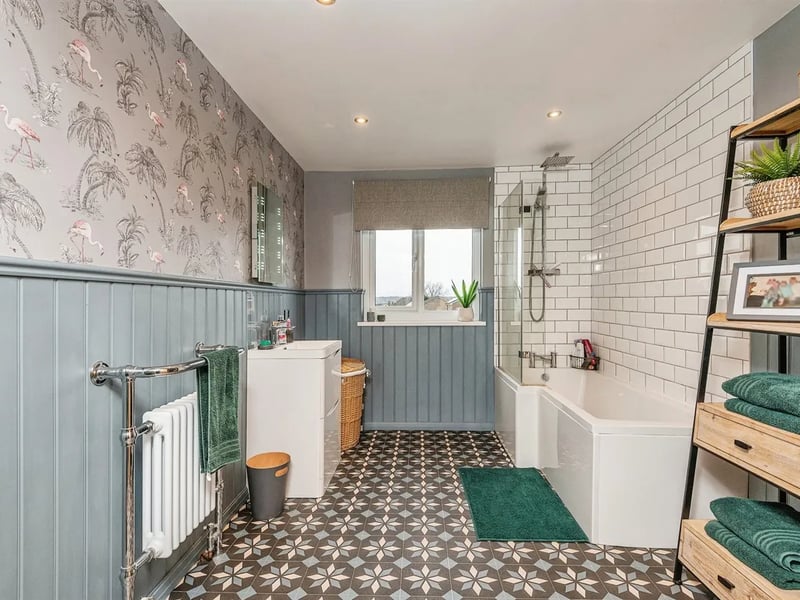 The stunning ensuite bathroom has a P-shaped bathtub with shower over.