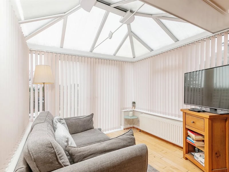 The sun room has wood floors and French doors to the garden.