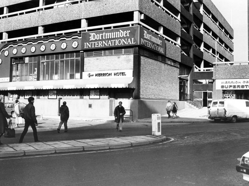 the Merrion Centre from Wade Lane, with the Dortmunder International public house in the centre. The entrance to the Merrion Centre Superstore is on the right. Pictured in February 1985.