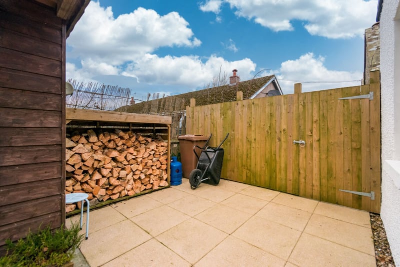 The lovely patio area to the rear of the property, with a useful log store and shed that is perfect for barbeques in the summer months.