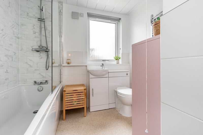 The bathroom is fitted with a three-piece suite featuring a fantastic mains rainwater shower over the bath. 