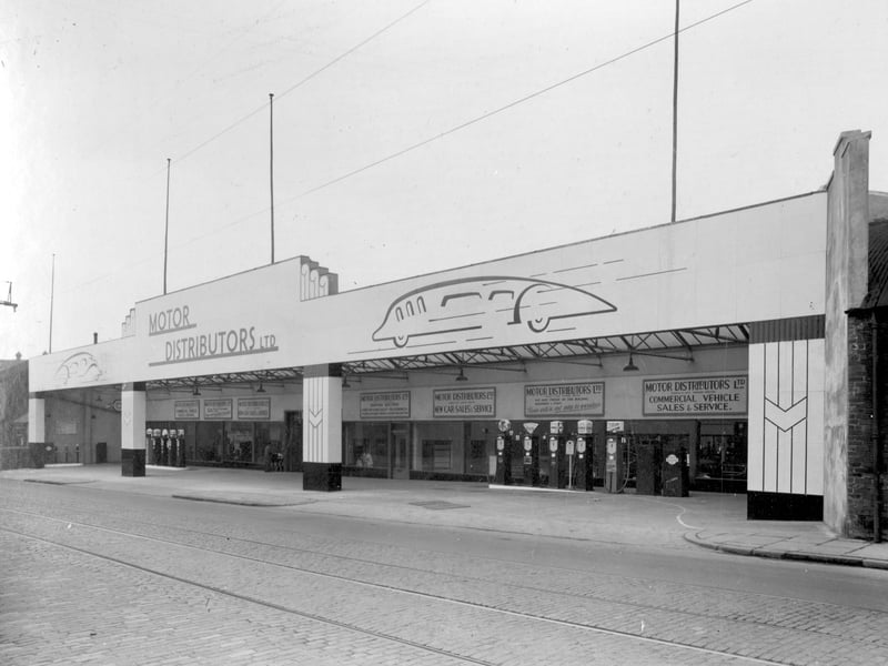 The newly-opened premises of Motor Distributors Ltd on Stanningley Road in April 1937. The car showroom is in focus with covered forecourt and petrol pumps.