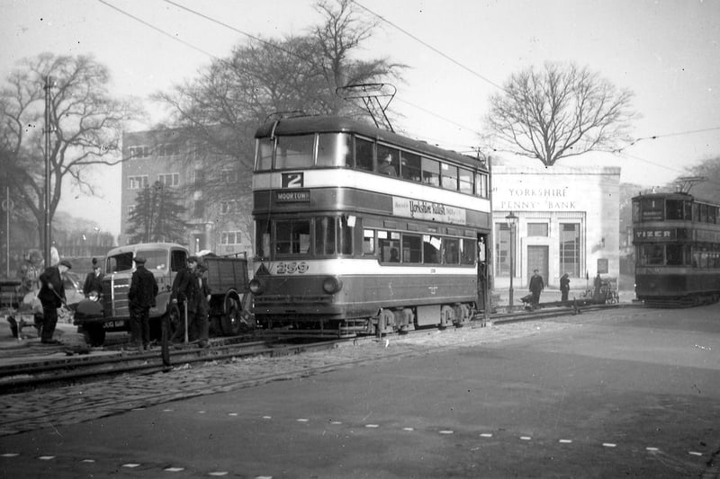 The junction of Harrogate Road and Potternewton Lane in June 1947. In the foreground is a street lamp and a belisha beacon. Behind, on a house wall is a large poster for Yardley lavender toiletries, to the right is a poster for Oxydol detergent.