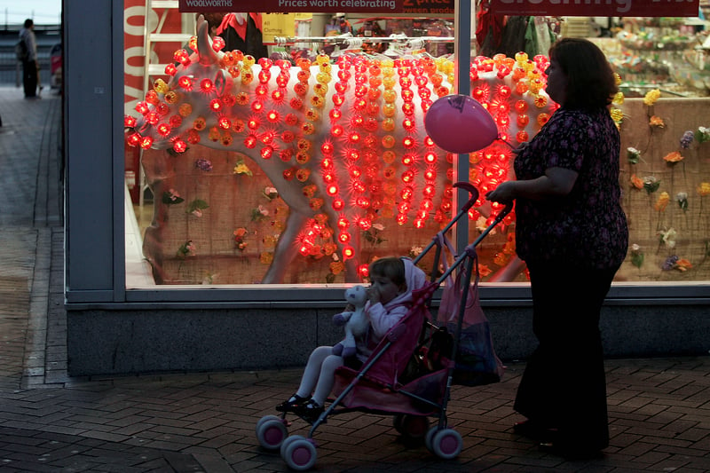 A woman and her child are seen standing by an illuminated cow in Blackpool on October 5, 2005