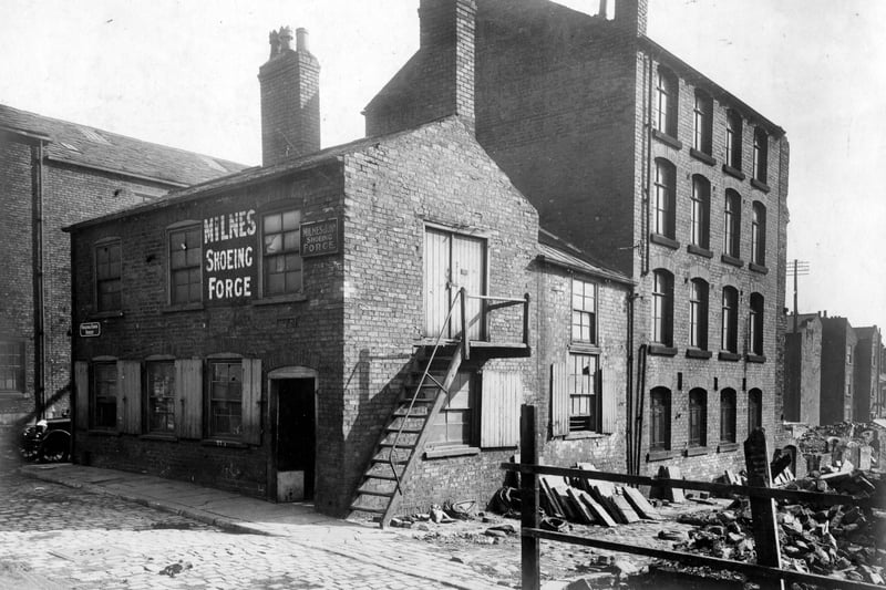 This is Virginia Cross Street, with Milnes and Son shoeing forge. Virginia Street mills is undergoing demolition. This is a rear view from Back Virginia Street. Pictured in September 1928.