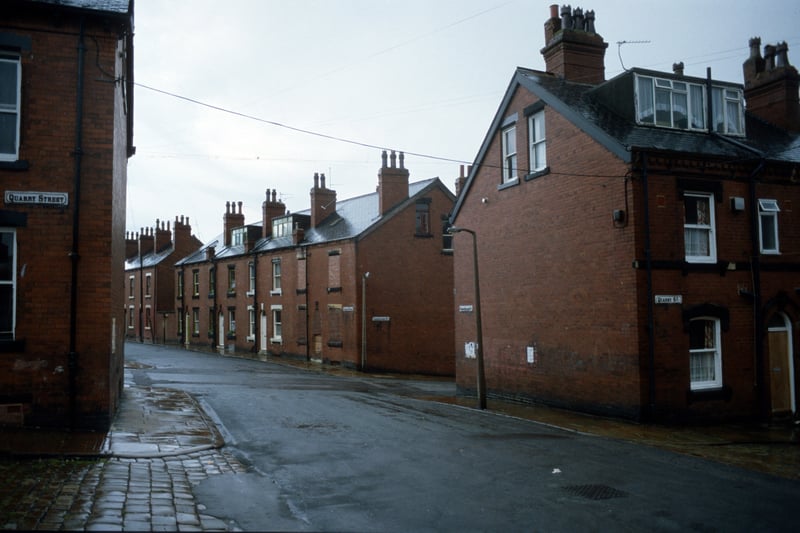 Looking east along Cross Quarry Street from the junction with Quarry Street. After the next junction (Christopher Road) Cross Quarry Street becomes Glossop Street where a row of red brick terraced houses numbered 2 to 10 are seen. In the foreground are nos. 26 (left) and 24 (right) Quarry Street which are back-to-backs with 25 and 23 Christopher Road. Pictured in August 1985.