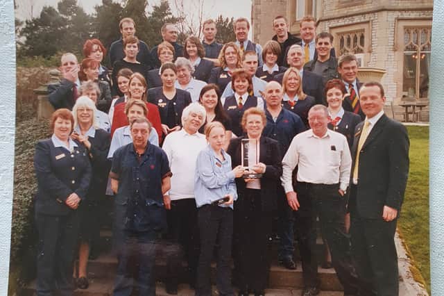 A photograph from when the Kenwood Hotel won 'Hotel of the Year' - Violet is in the front row, holding the trophy.