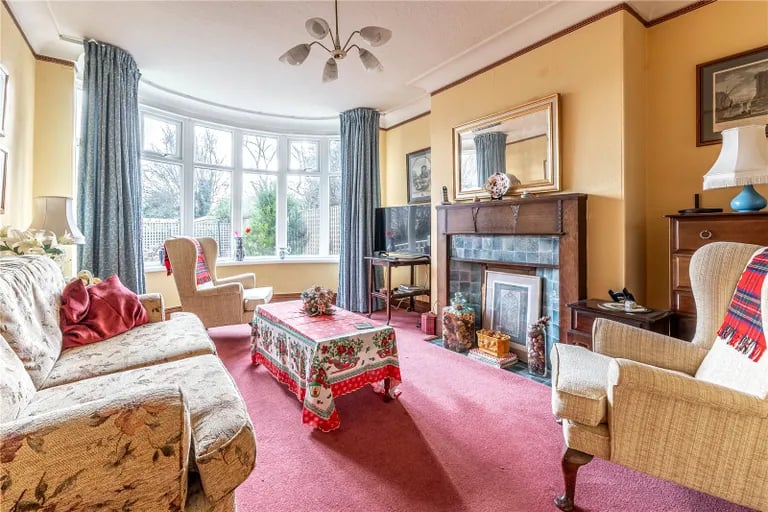The large living room gets lots of natural light from the circular bay window.