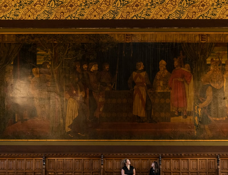 Building manager, Lisa Currathers, and communications officer, Jenny Francis, sit under a Magna Carta mural by the pre-Raphaelite painter Henry Holiday inside the Great Hall.