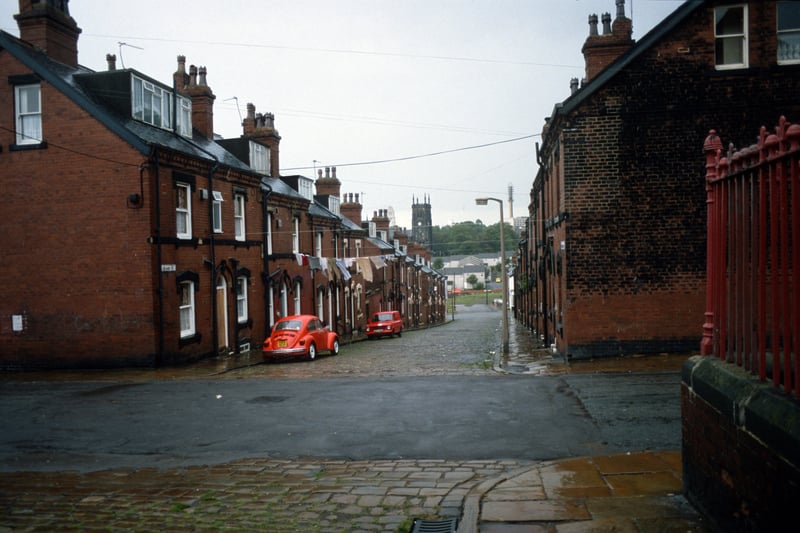 Looking south down Quarry Street past the junction with Cross Quarry Street in the foreground. A fence on the right encloses the grounds of Quarry Mount Primary School. St. Mark's C. of E. Church is seen in the background. Pictured in August 1985.