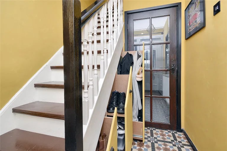 Enter into a colourful hallway with tiled flooring and handy pull-out storage racks.