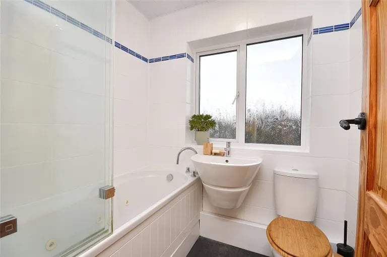 The family bathroom is a modern three piece suite with a bath.