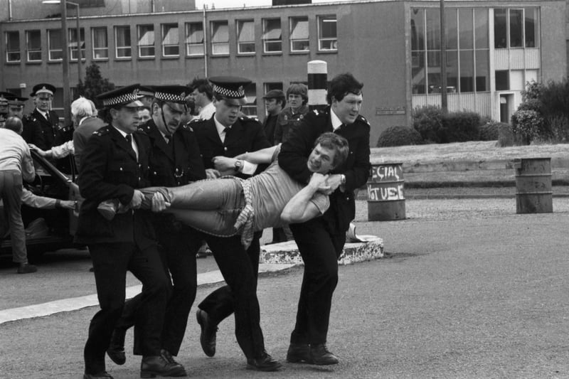 Members of the NUM miners' union picket line clash with police outside Bilston Glen colliery during the miners strike  in June 1984. Four policemen carry a picket away.