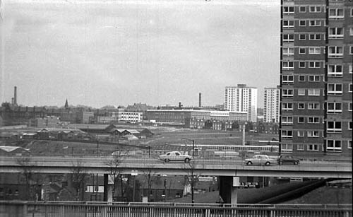 A raised section of Lovell Park Road runs across the foreground of this view. On the right edge, Lovell Park Towers flats are visible. In the background St James's Hospital can be seen to the left with flats on the Shakespeare estate to the right. View looks across Sheepscar, then Burmantofts.