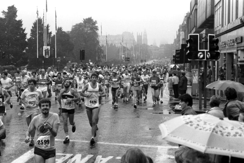 Competitor running along Princes Street in the rain during the Edinburgh Marathon in September 1984.