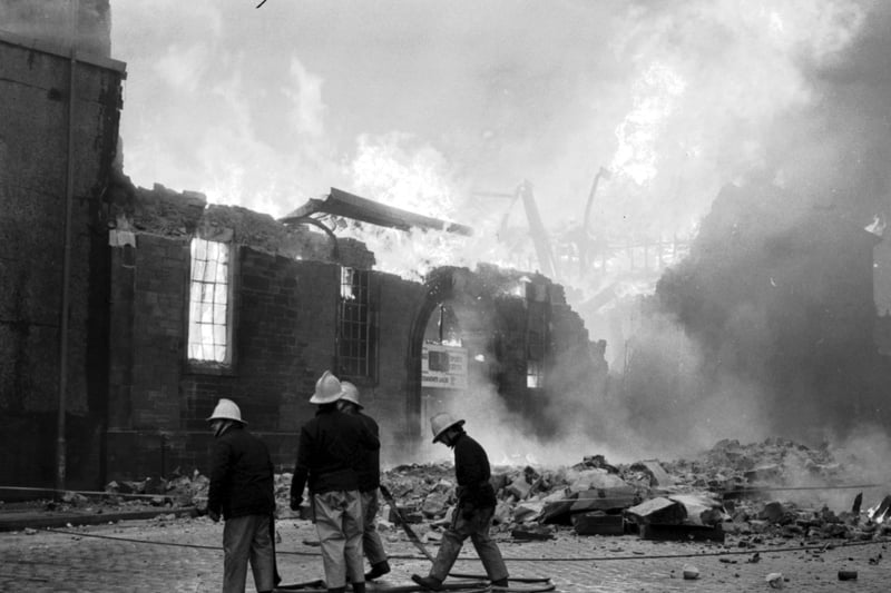 Firemen attend the fire at the Courage private sports centre in Leith, March 1984.