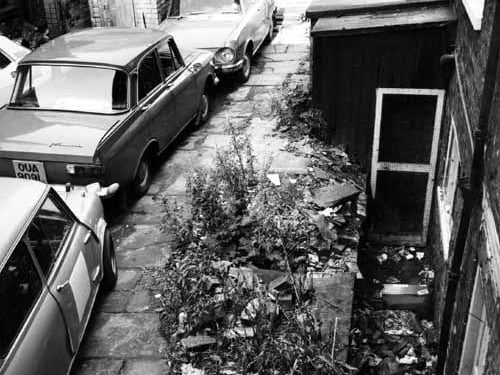 A derelict property in Queen Square awaiting demolition. Cars are parked on the stone flags. Pictured in October 1974.