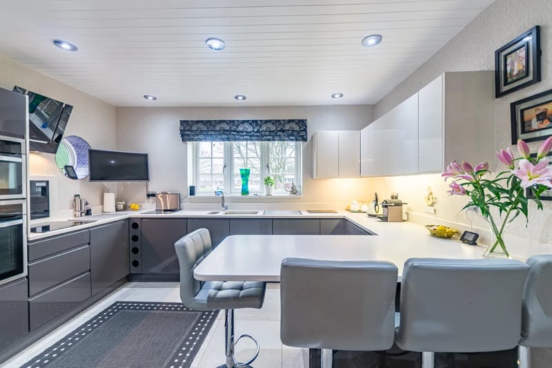 The separate breakfast kitchen features a range of base and wall units and appliances in a stylish grey finish.