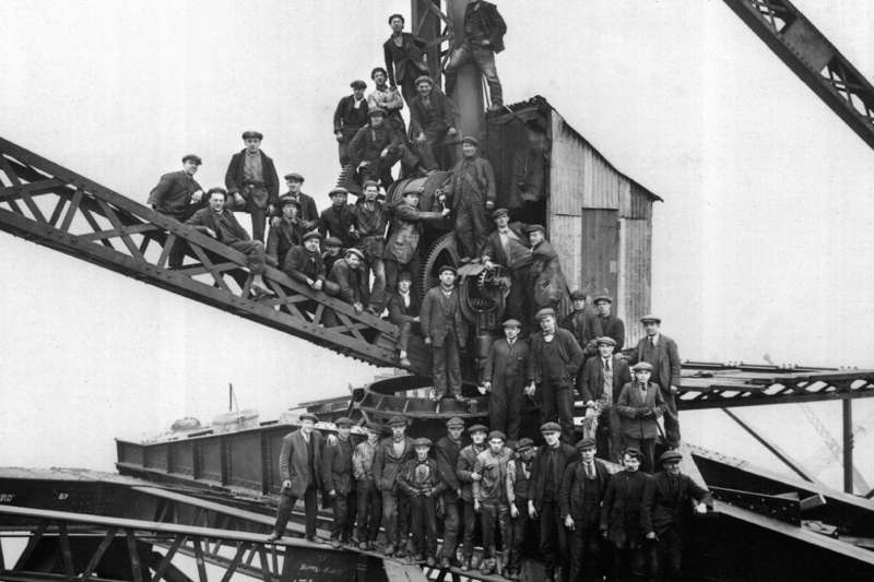 A wonderful image as steel erectors, riveters and crane drivers perch on a 20-ton capacity crane to mark the completion of the Tyne Bridge arch, 23 February 1928 