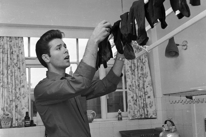 27th August 1963, British pop star Cliff Richard hangs up his socks to dry in the kitchen of his home in St Anne's, Blackpool.  (Photo by John Drysdale/Keystone Features/Getty Images)