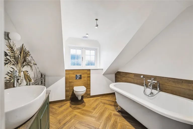 The gorgeous bathrooms have roll-top bath and wooden floors.