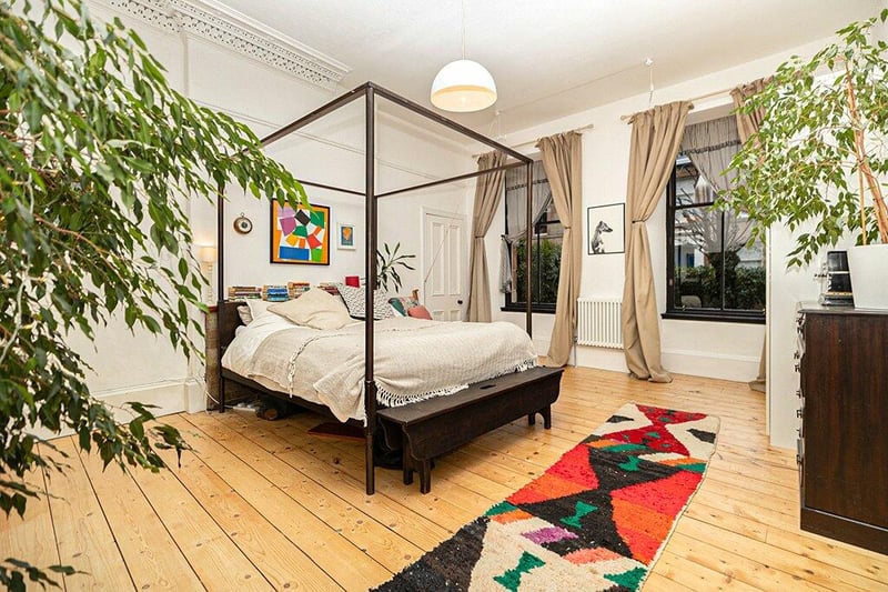 Inside the expansive bedroom one with cornice detailing and refurbished floorboards. 