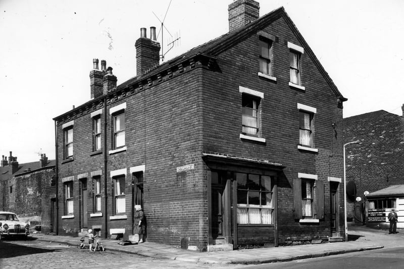 On the left is Cross Longley Street, a woman is at the door of number 2, 4 is to the left. The house with the shop window front is number 218 Jack Lane, next right is 216, listed as home of George Ward. The yard on the right also belonged to George Ward who was a haulage contractor. It had its own petrol supply, the pumps can be seen. Pictured in June 1964