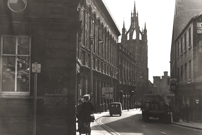  A view of the Groat Market Newcastle upon Tyne taken c.1963. The photograph is looking south towards St Nicholas Cathedral. The Town Hall is in the foreground to the left. There is a pub on the right-hand side with a lorry containing beer barrels parked outside. St Nicholas Cathedral the Black Gate and the Keep can be seen in the background. 
