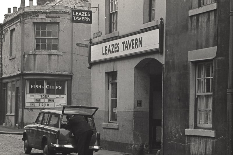 Photograph taken in 1964 of the Leazes Tavern in Leazes Lane. In the foreground a man is unloading something from the boot of his car. A fish and chip shop is on the opposite corner to the pub.