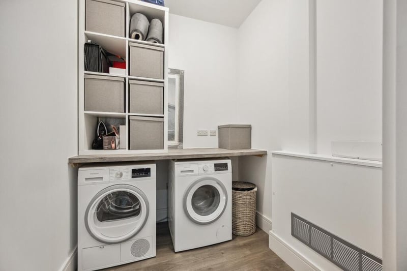 The utility cupboard has substantial storage space and contains a Siemens washer & dryer. 