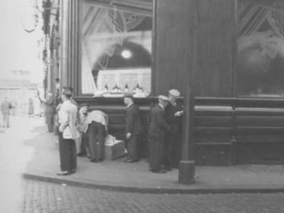 A newspaper seller outside an old pub on Dumbarton Road