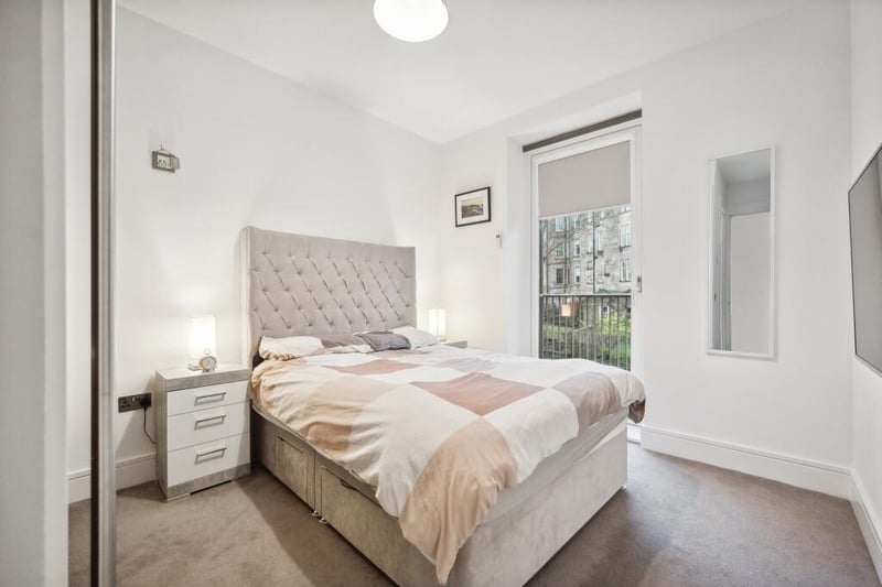 The principal bedroom space provides access to a large balcony facing the well-kept gardens. 