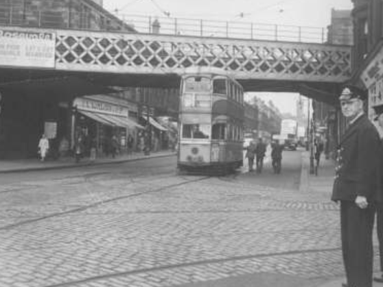 A traffic official keeps an eye on Dumbarton Road as the tram passes.