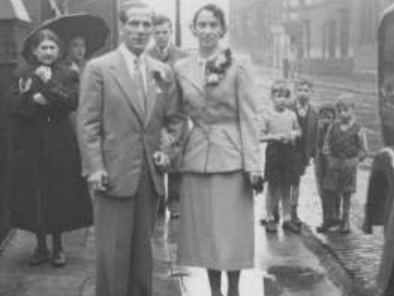 A newly married couple pose for a picture outside a Partick church