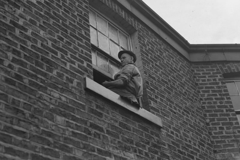 A resident makes sure his upstairs windows are spotless.
