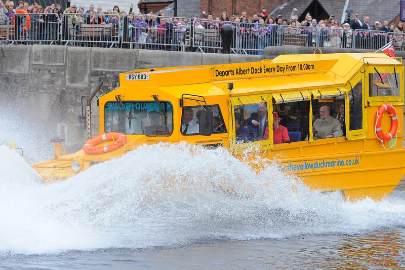 Britain's late Queen Elizabeth II and Prince Philip ride on a Yellow Duckmarine boat in Salthouse Dock on May 17, 2012.     