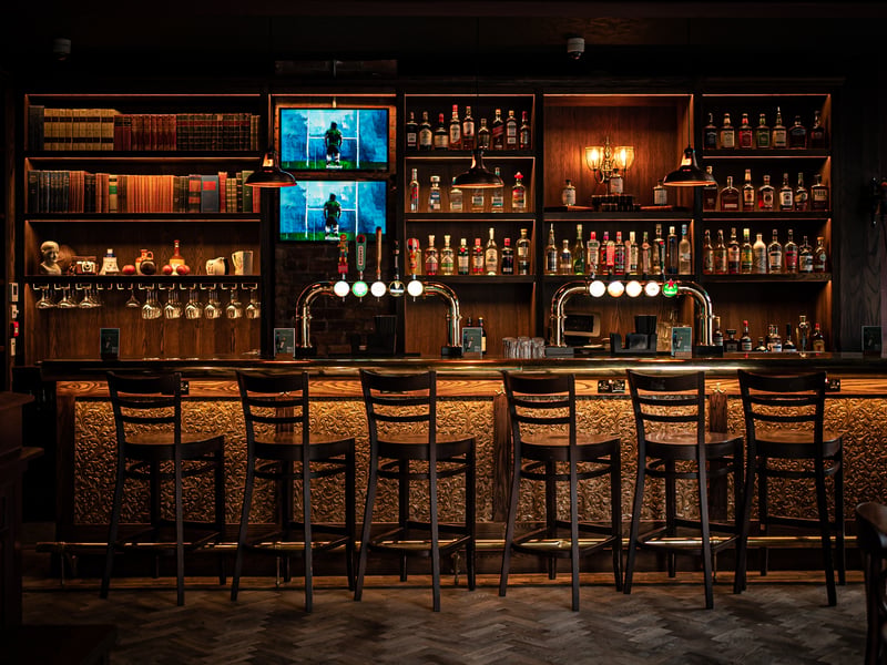 The tiled bar front is in British heritage colours and vintage sports memorabilia lines every wall