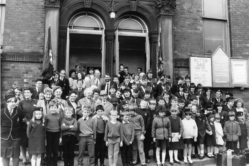 members of the congregation of Upper Armley Methodist Church gathered together for the final service held on Sunday, May 10, 1987. The church was to be demolished and rebuilt as a Community Centre with £213,000 funding via an Urban Programme grant. In the centre, towards the back, is the Minister of the Church, Reverend Gordon Lister, with Councillor John Battle, Chair of the Council's Urban Development Committee. Also in the picture are representatives of the Girls' and Boys' Brigades. The new centre was to include a luncheon club, a playgroup, adult education classes, a credit union and an advice and counselling service for families. Upper Armley Methodist Church was built in brick in the Italian style and dated from 1878.