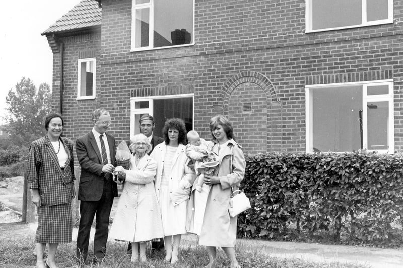 Coun George Mudie presents keys to new tenants of Brander Mount. This was the conversion of 12 'cottage' style flats to 6 2-bedroomed semi-detached homes, carried out under the Priority Estates Programme and the Community Refurbishment Scheme. It was part of a long-term plan by Leeds City Council to improve the standard of older housing estates in the city. The houses were equipped with new bathrooms, central heating, new roofing, re-wiring and new doors and windows at a cost of £20,000 each. The new tenants pictured are Geoff, and Brenda Bull with Mrs. Bull's mother, Lizzie Speight and Jane Green with her nine month old daughter, Rachel.