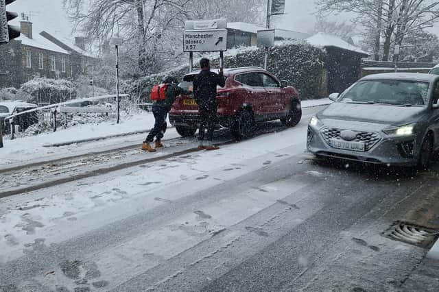 Caring residents push a stranded car on Manchester Road, Broomhill. Picture: David Kessen, National World