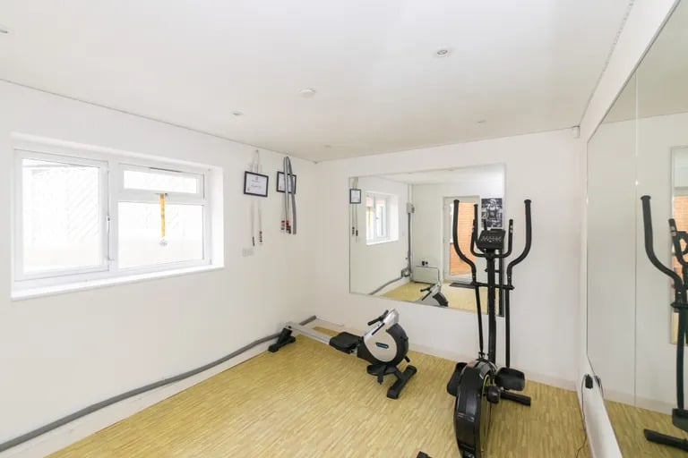 Across the covered patio is a private gym and utility room.