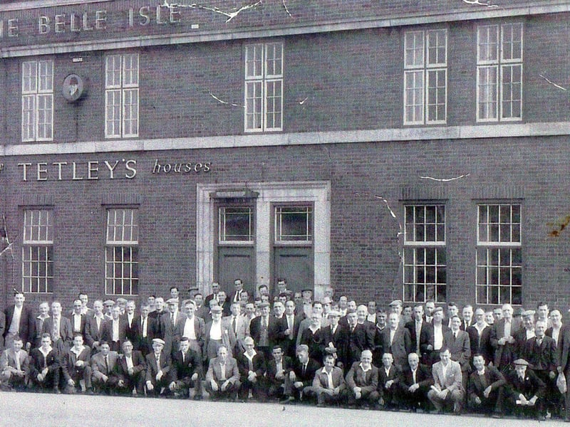 A large group of men pose for a photo outside the large, brick-built premises of the Belle Isle Hotel on Low Grange Crescent circa 1956/57. The men are smartly dressed in suits, with some sporting flat caps, and they are obviously gathered together for an occasion such as an outing. Since 1988 the former Belle Isle Hotel has operated as a privately owned Care Home and is known as Victoria House Residential Home.