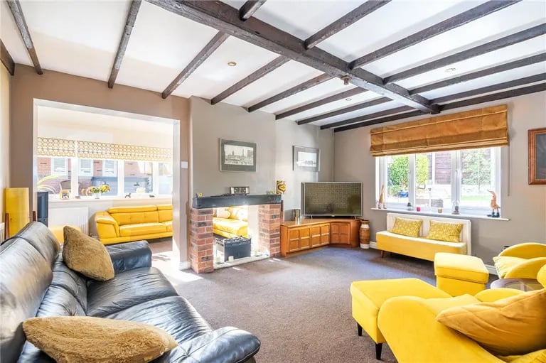 A bright living room with exposed ceiling beams.