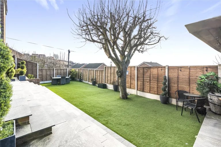 The rear garden has been landscaped and features multiple patio areas.