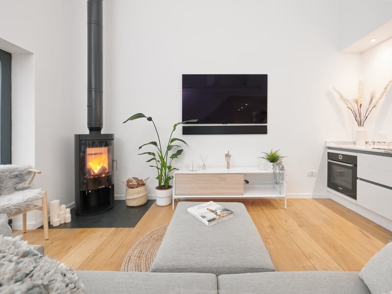 The open plan living and kitchen space has a TV and a log-burner.