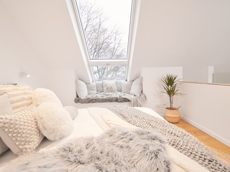 The bedroom is festooned with comfy cushions.